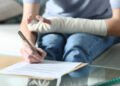 Disabled woman with bandaged arm signing document