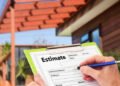 Hand writing an estimate on a clipboard for Home Building Renovation